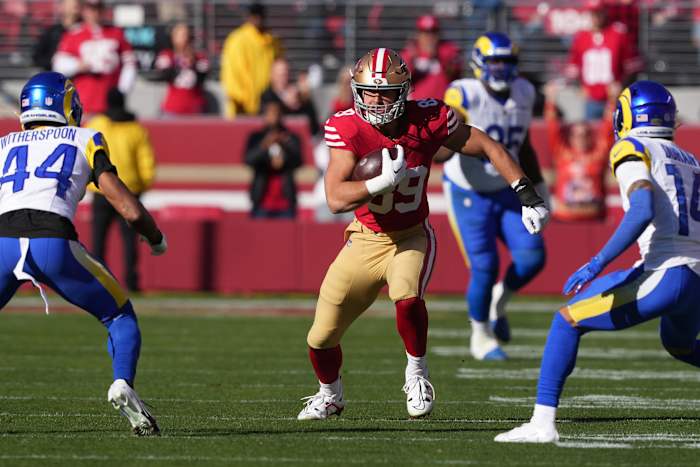Jan 7, 2024; Santa Clara, California, USA; San Francisco 49ers tight end Charlie Woerner (center) runs after a catch against Los Angeles Rams cornerbacks Ahkello Witherspoon (44) and Cobie Durant (14) during the first quarter at Levi's Stadium. Mandatory Credit: Darren Yamashita-USA TODAY Sports